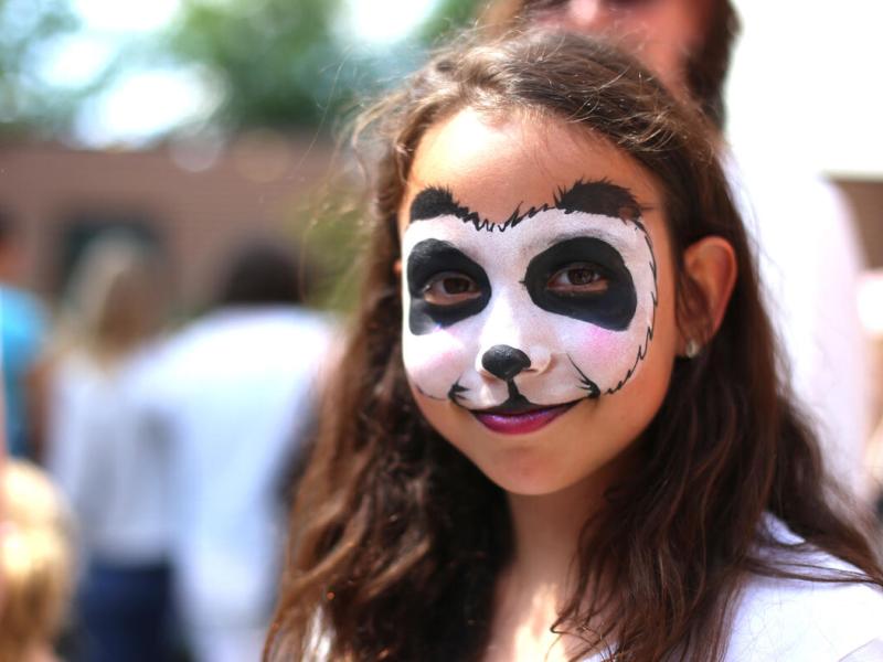 Girl with face painted like a panda